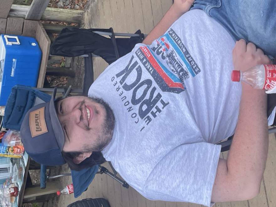 Adam relaxing in a camp chair wearing a Leapley cap