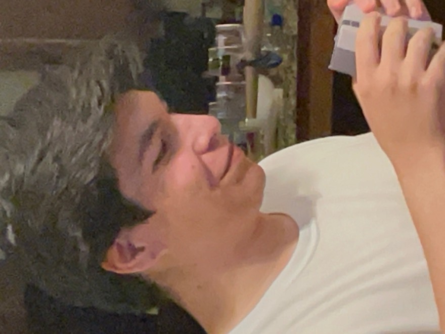 Eric smiling and examining a small gift in his hands