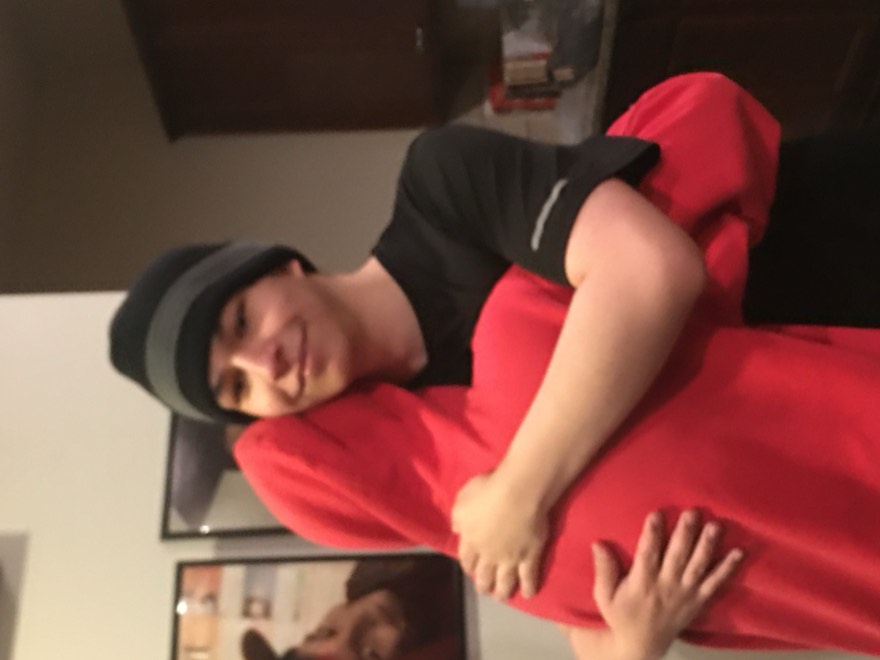 Eric in a beanie hugging someone in a red hoodie