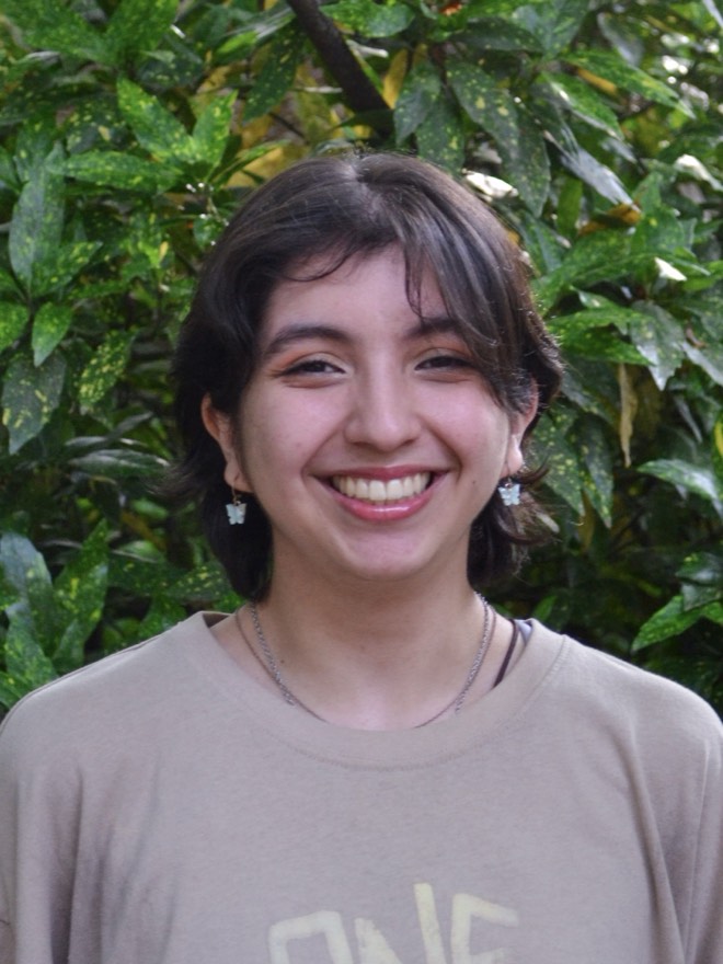 Megan smiling to camera in front of greenery